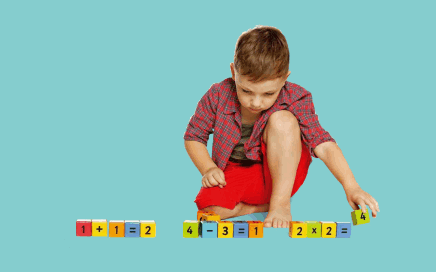 Imatge d'un nen jugant amb blocs multibase d'operacions matemàtiques